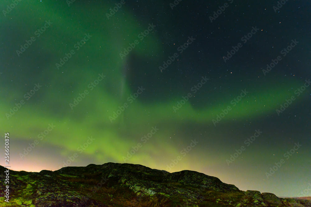 Green northern lights over the hills, aurora.