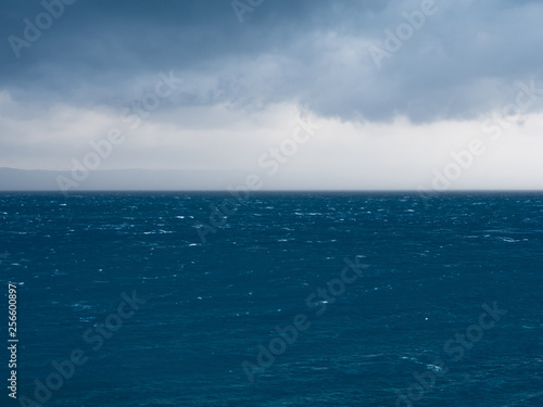 Strong wind and rainy clouds over blue sea