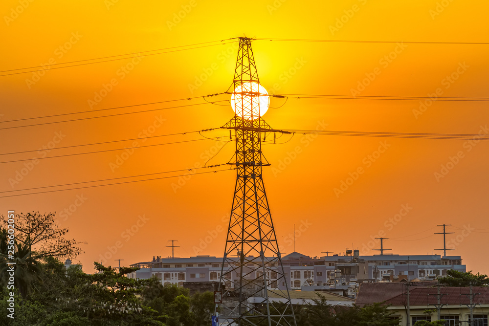 Electricity pole silhouett and the sun at sunset, they show the continuous energy when the sun goes down, the electric energy will supply the whole city through the above pillars.