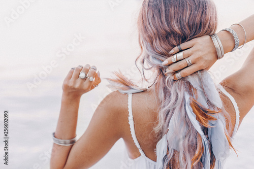beautiful young boho woman close up with pink feathers and accessories at sunset photo