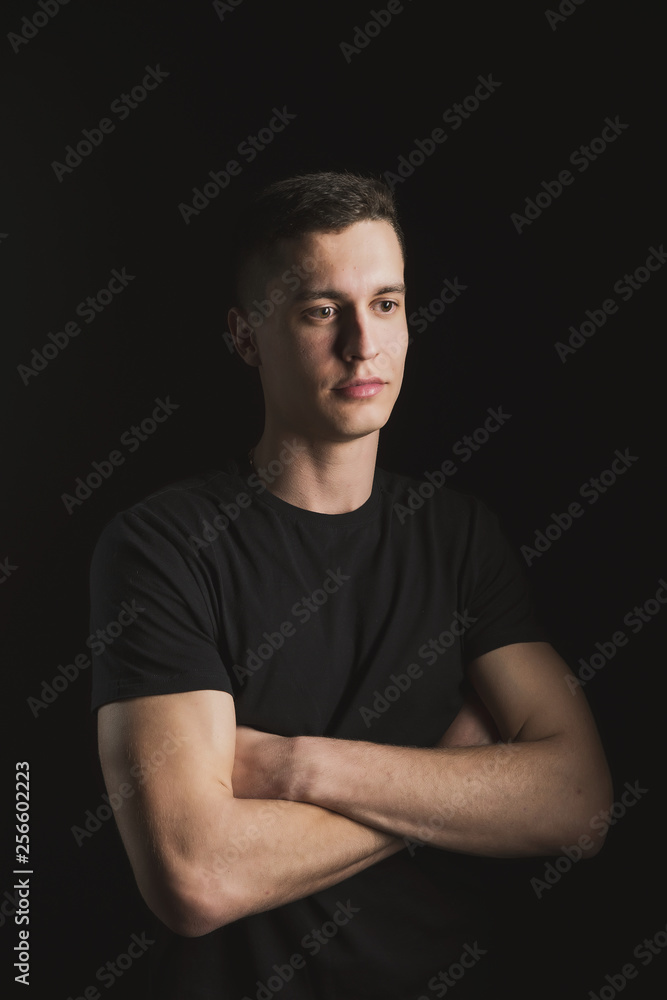 Beautiful, slender young man in black t-shirt on black background and on the street Beautiful, slender young man in black t-shirt on black background and on the street