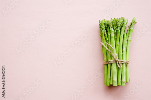 Bunch of fresh asparagus on delicate pink pastel background