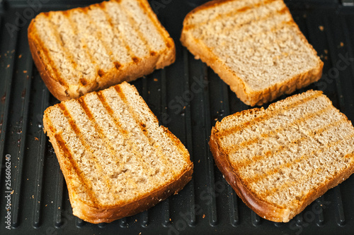 Toasted bread on the electric grill. Grilled bread and butter. Delicious slices of bread.