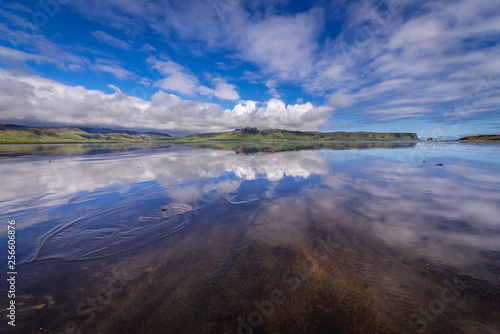 Reflection in the water of Dyrholaos estuary near cape Dyrholaey in Iceland