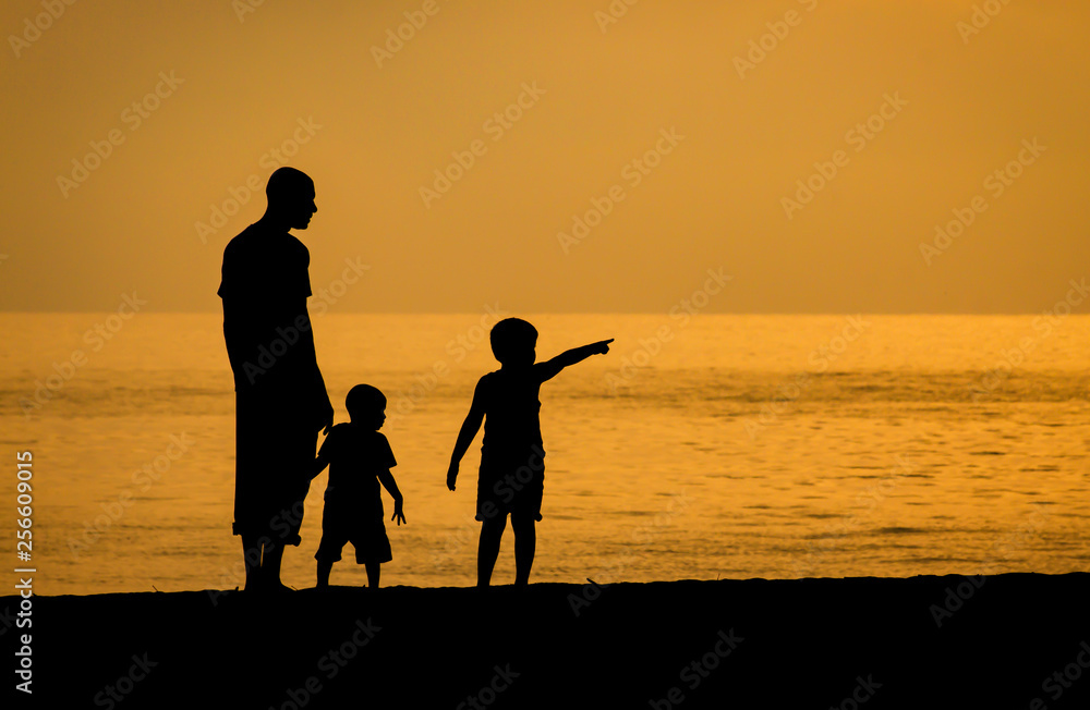 father and son on the beach at sunset