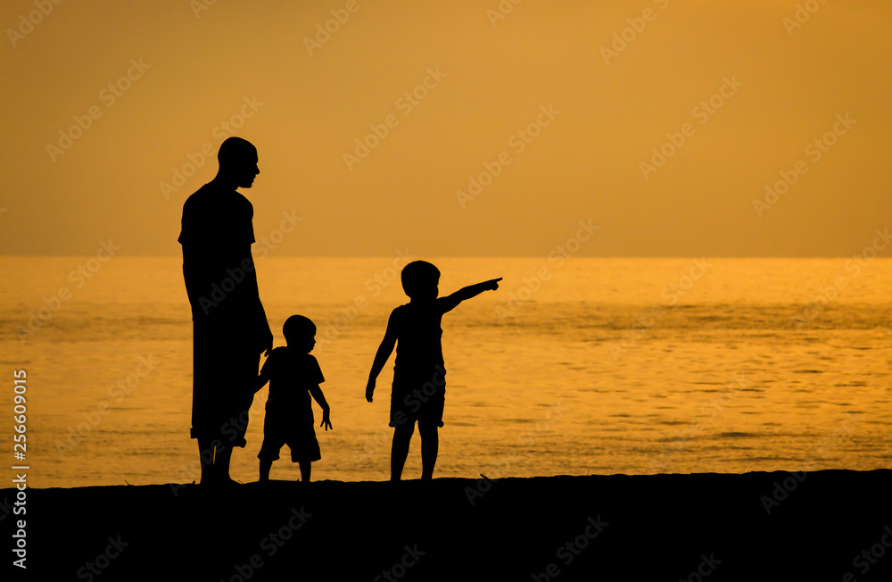 Fototapeta premium father and son on the beach at sunset