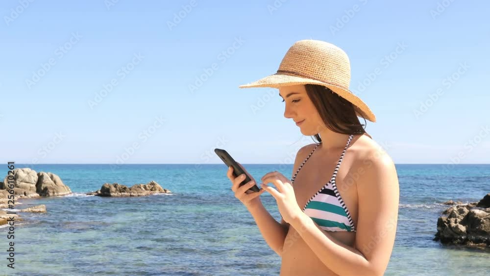 Amazed tourist in bikini checking smart phone content on vacation on the beach Amazed tourist in bikini checking smart phone content on vacation on the beach