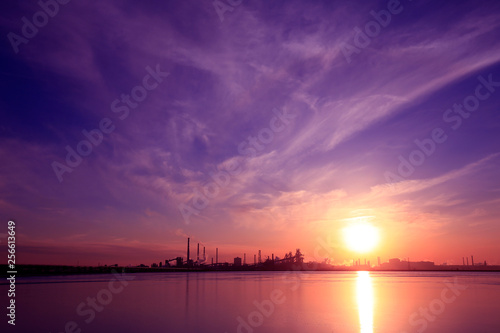 A silhouette of a chemical plant in the setting sun