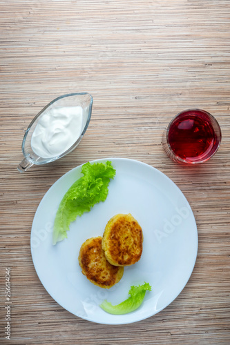 Healthy dish of potato patties with lettuce, sour cream and juice