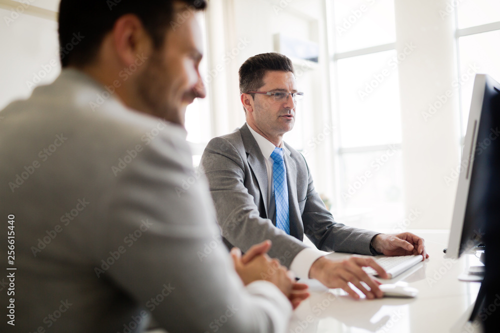 Image of two handsome businessmen using computer at meeting Image of two handsome businessmen using computer at meeting