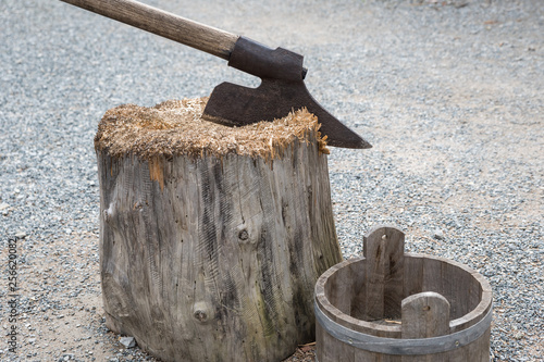 A hangman's ax stuck in a wooden trunk. photo