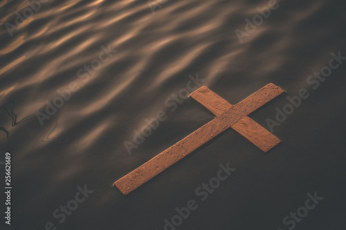 Wooden cross floating on water surface at dawn. Conceptual image baptism