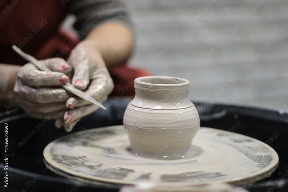 Hands of a Potter creating the clay.  Vessel on the Potter's wheel.