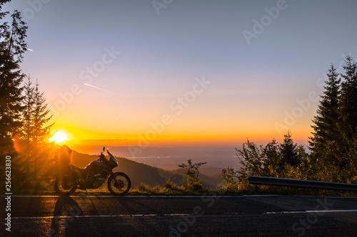 Adventure motorcycle, silhouette touristic motorbike. the mountain peaks in the dark colors of the sunset. Copy space. Concept of Tourism, adventures, active lifestyle, Transfagarasan, Romania