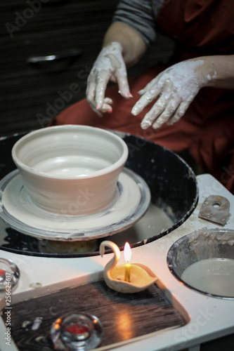 Hands of a Potter creating the clay.  Vessel on the Potter s wheel.