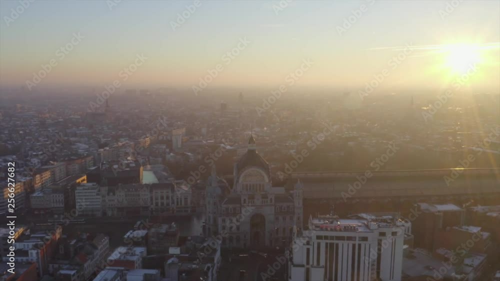 Video shows the beautiful train station in Antwerp with sunrise background. The sky orange sky