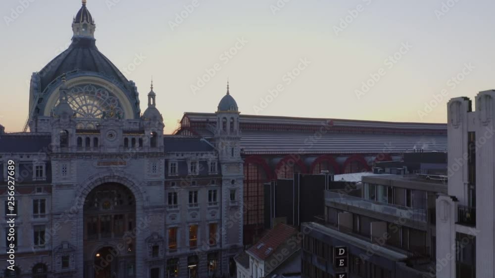 Video shows the beautiful train station in Antwerp with sunrise background. The sky orange sky