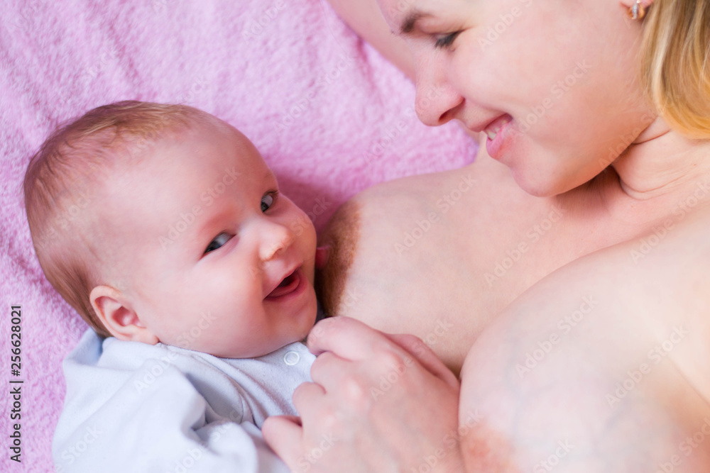 Mother breastfeeding baby. The girl has a funny look. Caucasian