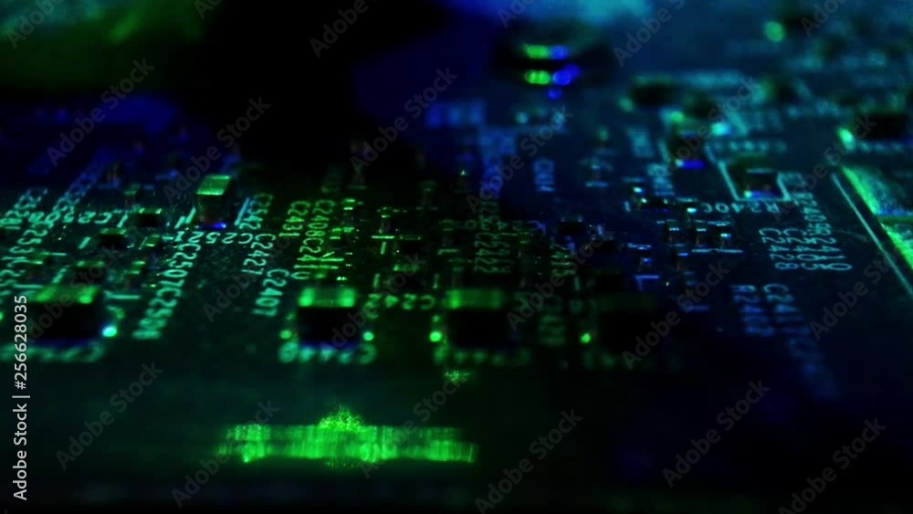 PCB components on a motherboard with green ambient light. Slow crawling shot on a slider. PCB components on a motherboard with green ambient light. Slow crawling shot on a slider.