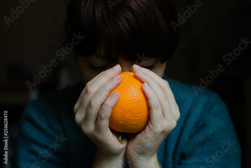 young woman holding an orange
