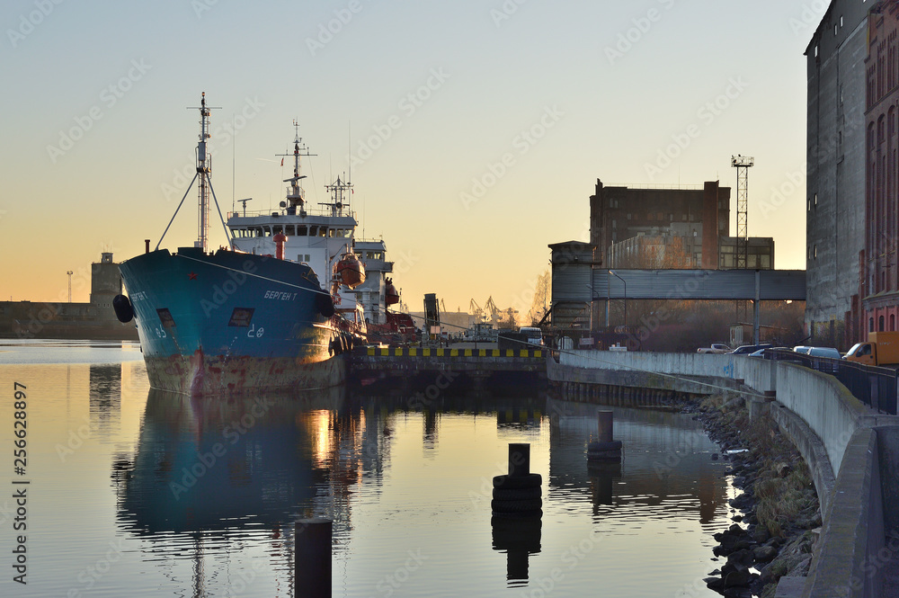 Fototapeta premium Fishing port with river and ship in spring sunny evening