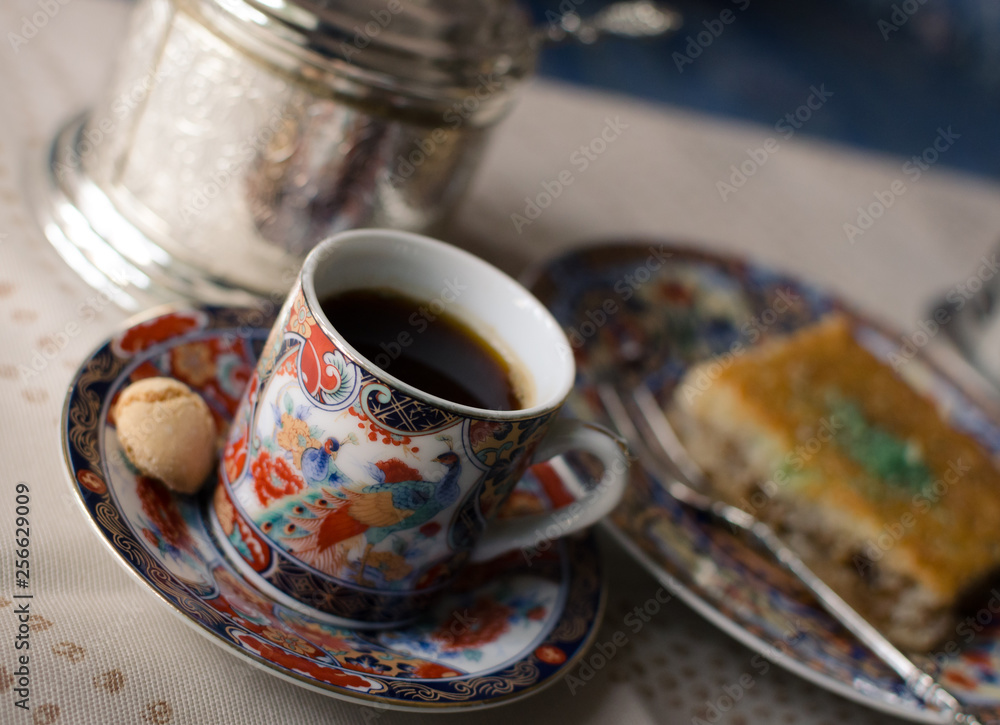 Fototapeta premium Vintage set of beautiful painted cup of coffee, honey cake Baklava and sugar bowl. Selective focus.