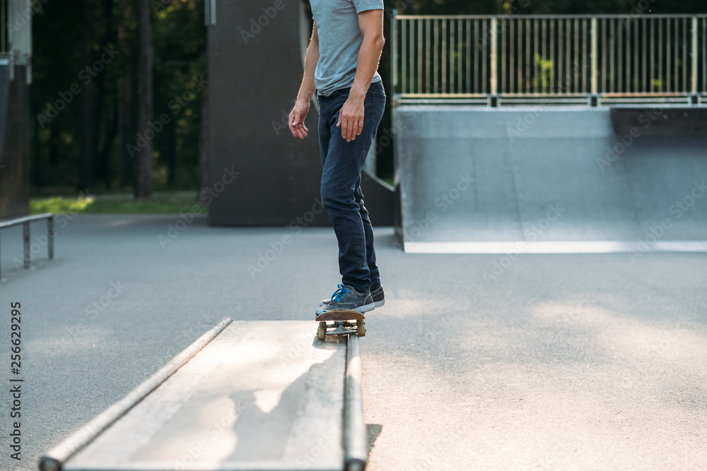 Youth hobby and lifestyle. Leisure and practice. Man riding skateboard in skate park. Cropped shot. Youth hobby and lifestyle. Leisure and practice. Man riding skateboard in skate park. Cropped shot.