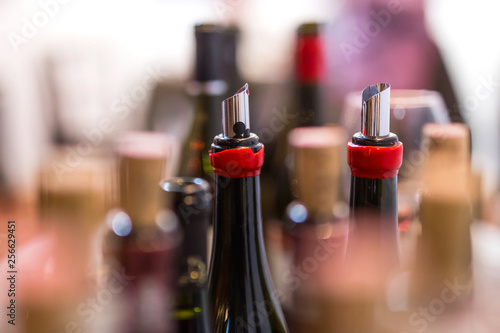 open wine bottles, flexible wine pourer, glasses, corks with blurred background at the wine tasting event