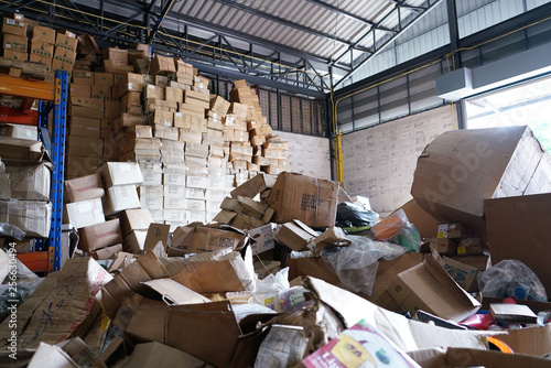 Blurry image of poorly organized warehouse with a lot of messy stocks and boxes photo