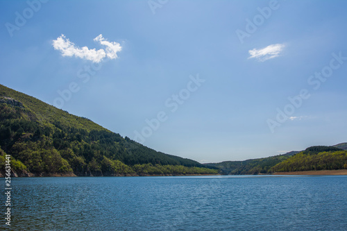 Mountain lake at summer. Blue sky with small white clouds 