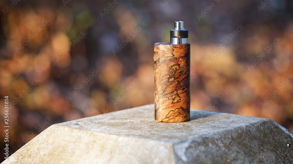high end natural stabilized wood box mods with rebuildable dripping atomizer on bokeh texture background, vaping device, selective focus high end natural stabilized wood box mods with rebuildable dripping atomizer on bokeh texture background, vaping device, selective focus