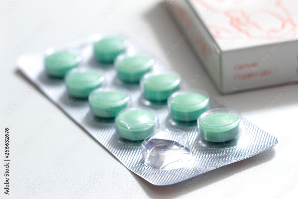 Packs of green pills on white background Packs of green pills on white background