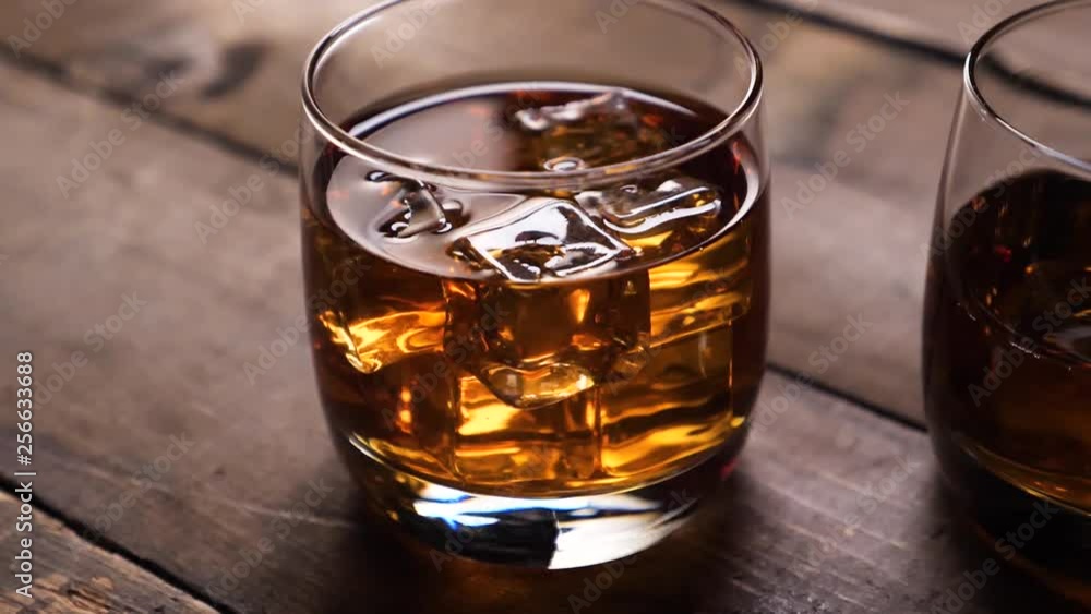 Golden Whiskey in the glass with nice reflection. With ice cubes. Golden Whiskey in the glass with nice reflection. With ice cubes.