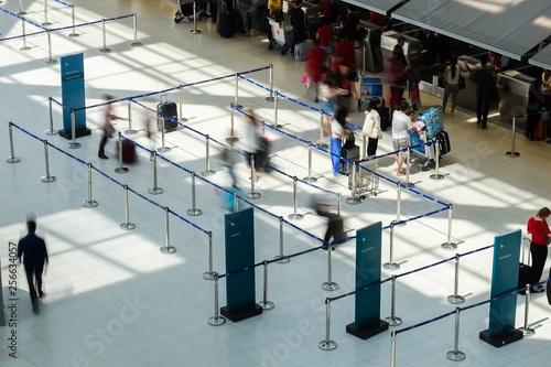 Abstract motion blurred image of people at the airport walking in line to their check in or departure gate