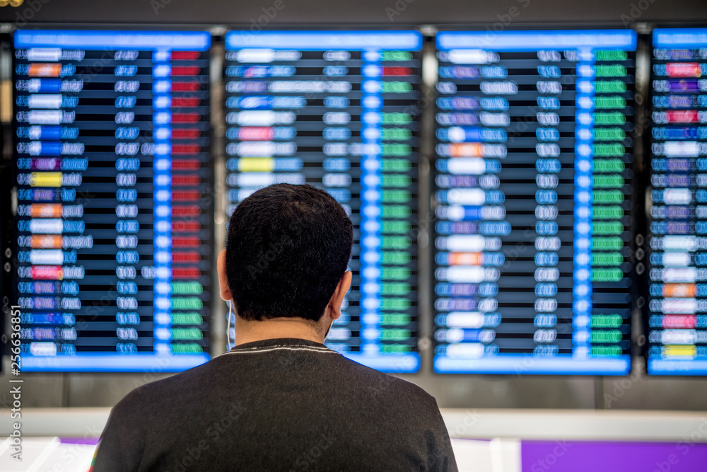 Fototapeta premium Man looking at the flights details board at the airport