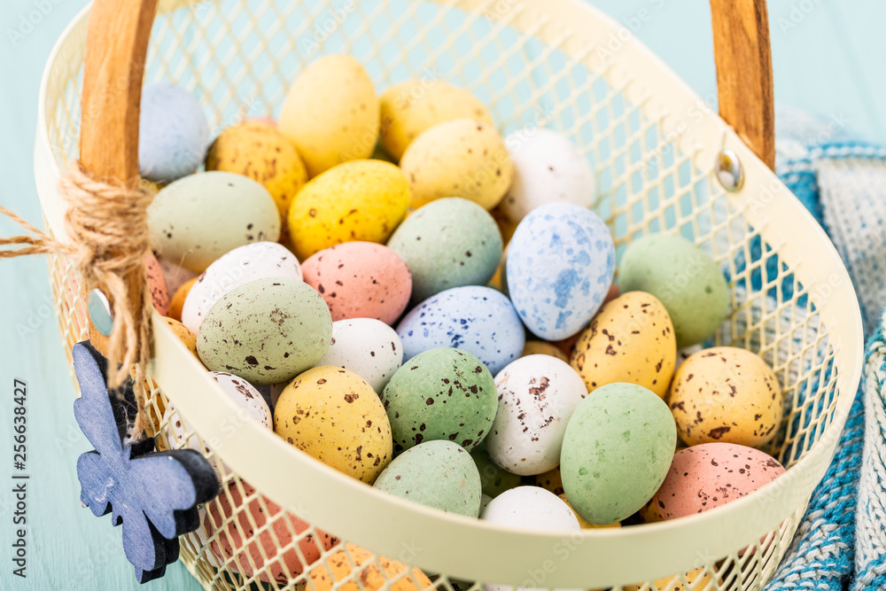 Metal basket with colourful Easter quail eggs. Spring holidays concept
