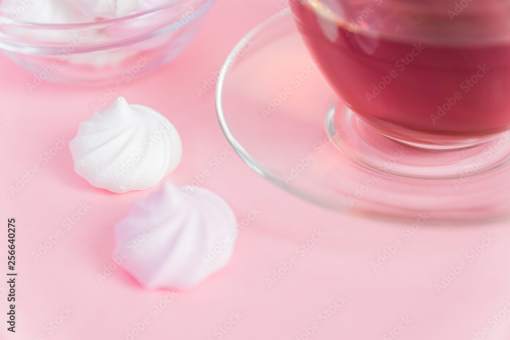 White and pink twisted meringues and cup of tea on pink background. French dessert prepared from whipped with sugar and baked egg whites. Greeting card with copy space White and pink twisted meringues and cup of tea on pink background. French dessert prepared from whipped with sugar and baked egg whites. Greeting card with copy space