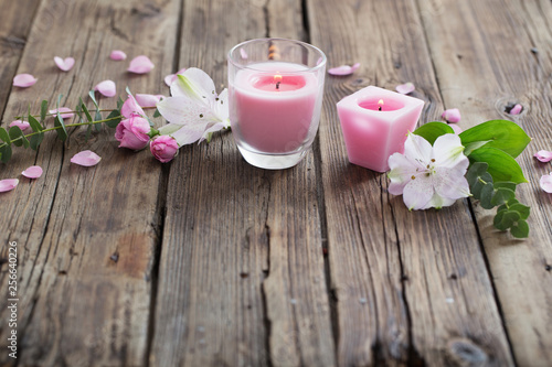 pink candles and flowers on wooden background