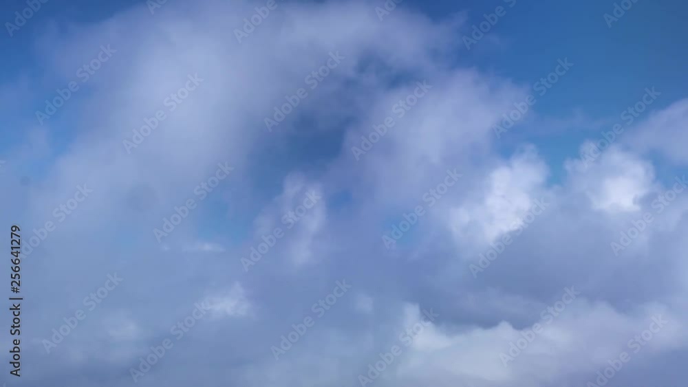 White clouds in blue sky from aircraft window. View from window flying airplane among fluffy clouds in blue sky. Heaven copy space background. White clouds in blue sky from aircraft window. View from window flying airplane among fluffy clouds in blue sky. Heaven copy space background.
