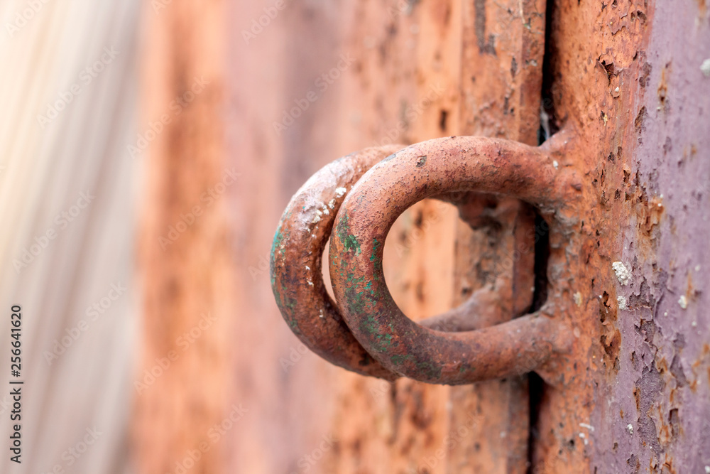 Iron hinges for a padlock on a metal door with old cracked paint and rust Iron hinges for a padlock on a metal door with old cracked paint and rust