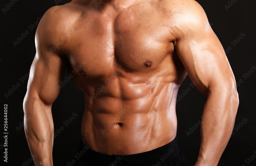 Portrait of young handsome muscular bodybuilder on black background torso close up view Portrait of young handsome muscular bodybuilder on black background torso close up view