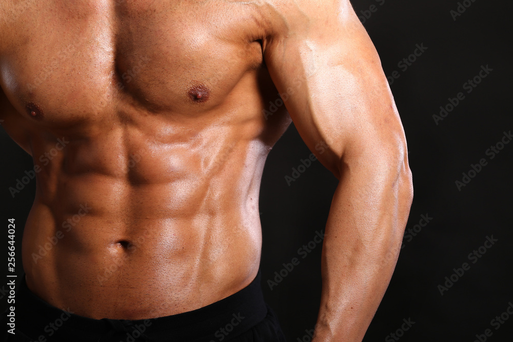 Portrait of young handsome muscular bodybuilder on black background torso close up view Portrait of young handsome muscular bodybuilder on black background torso close up view