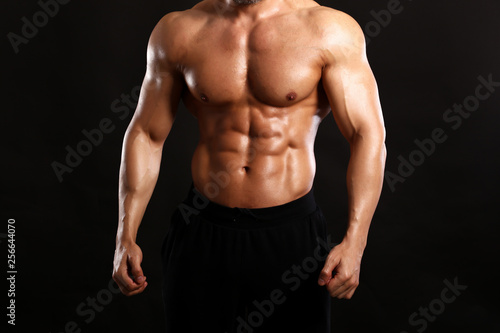 Portrait of young handsome muscular bodybuilder on yellow background 