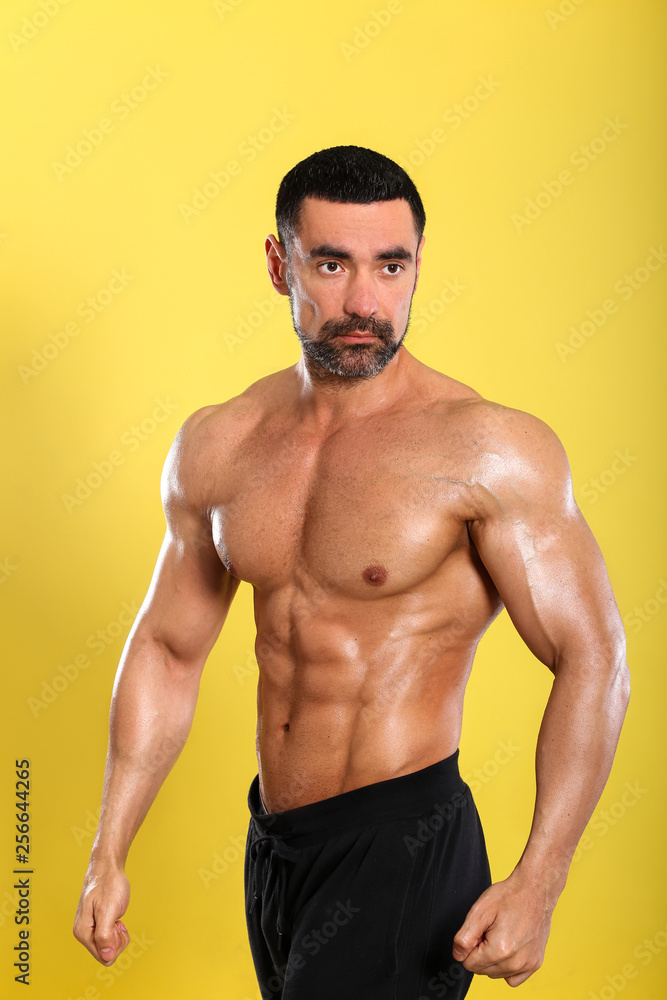 Fototapeta premium Portrait of young handsome muscular bodybuilder on yellow background 