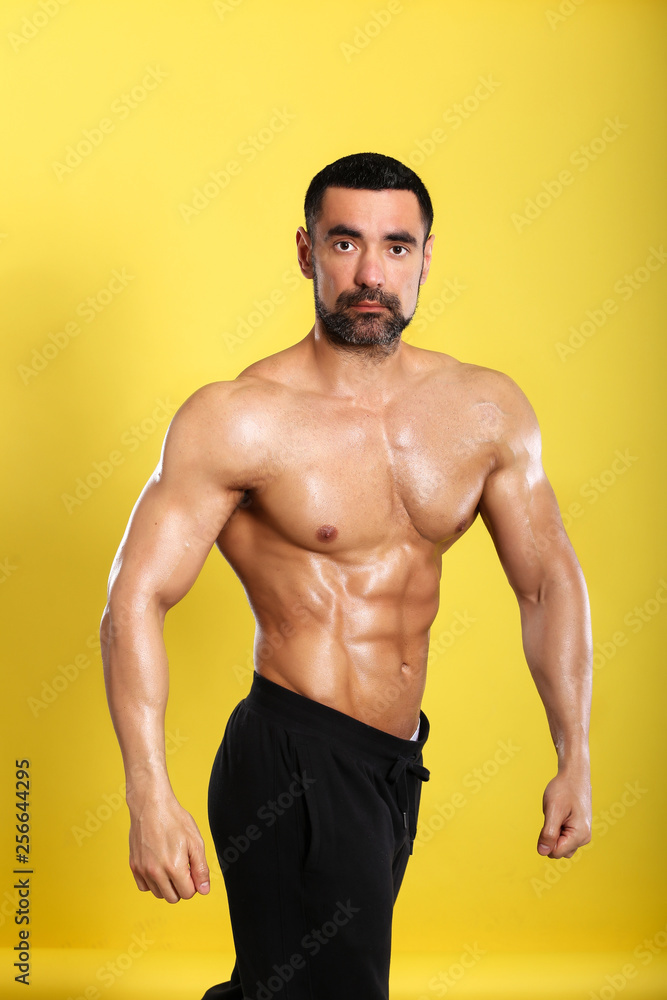 Fototapeta premium Portrait of young handsome muscular bodybuilder on yellow background 
