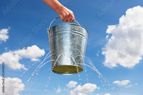 Man holding bucket with holes leaking water