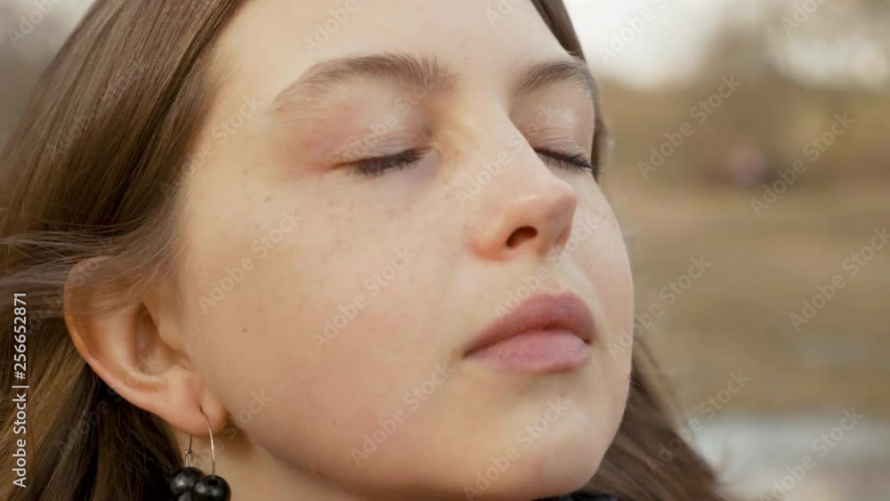 Close up portrait of enjoying woman standing on the wind Close up portrait of enjoying woman standing on the wind