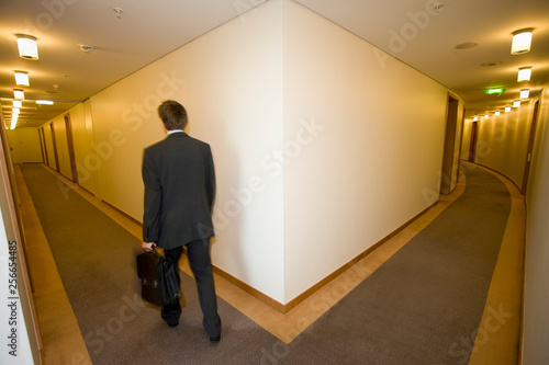 A businessman walking down a corridoor photo