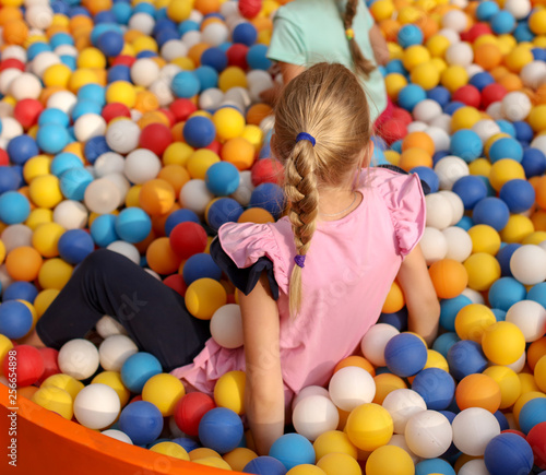 Girl playing in colorful balls on the attraction