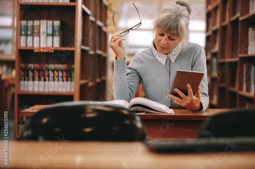 Canvas Print Woman reading a book in library